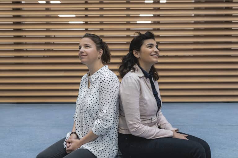 Twee vrouwen zitten met de rug naar elkaar toe