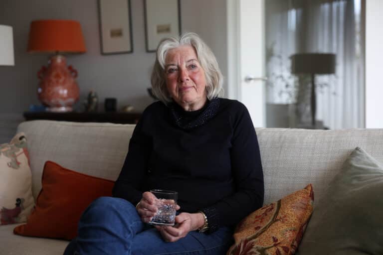 vrouw-zit-op-bank-in-huiskamer